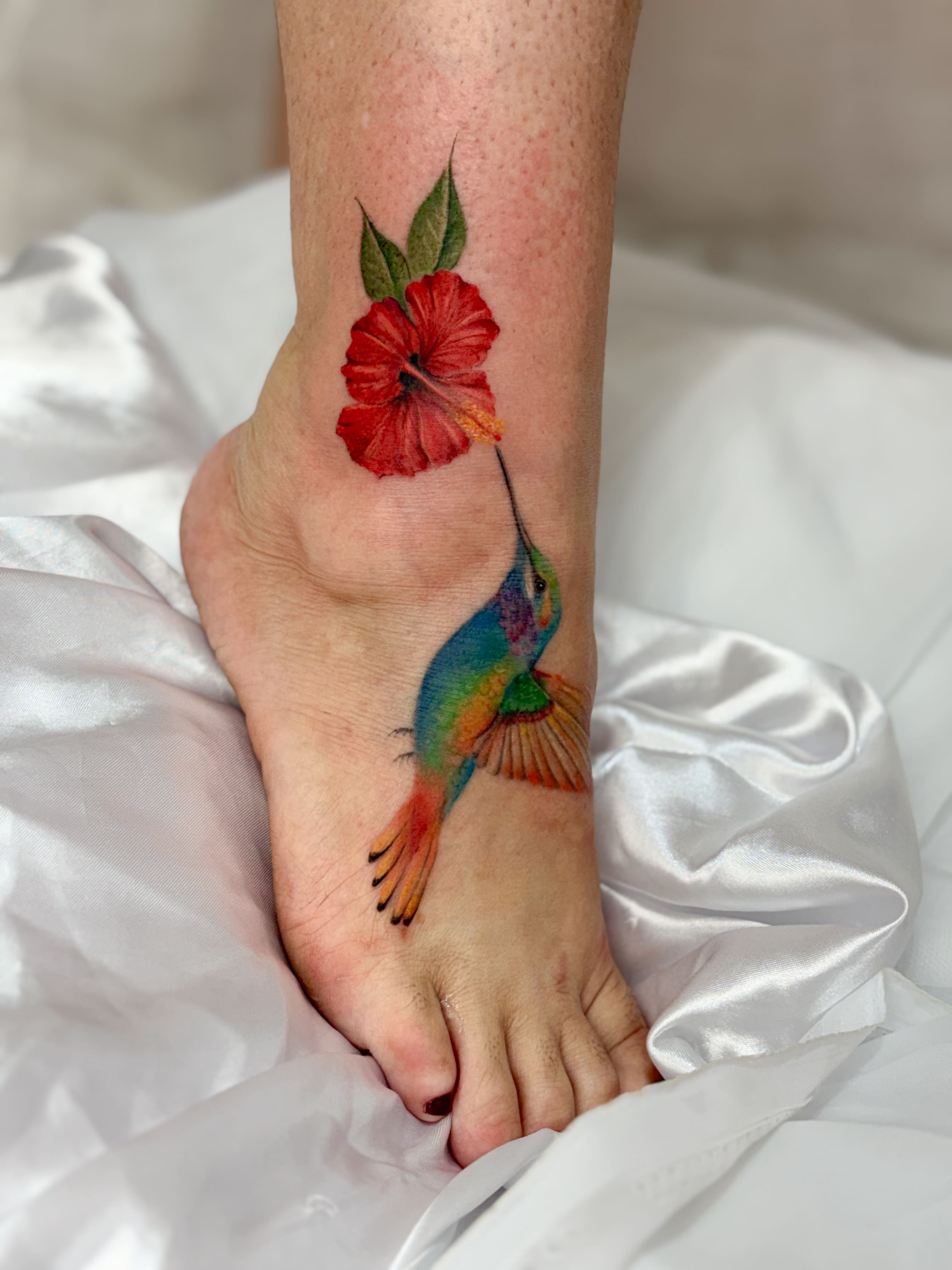 Tatuagem colorida de beija-flor e hibisco