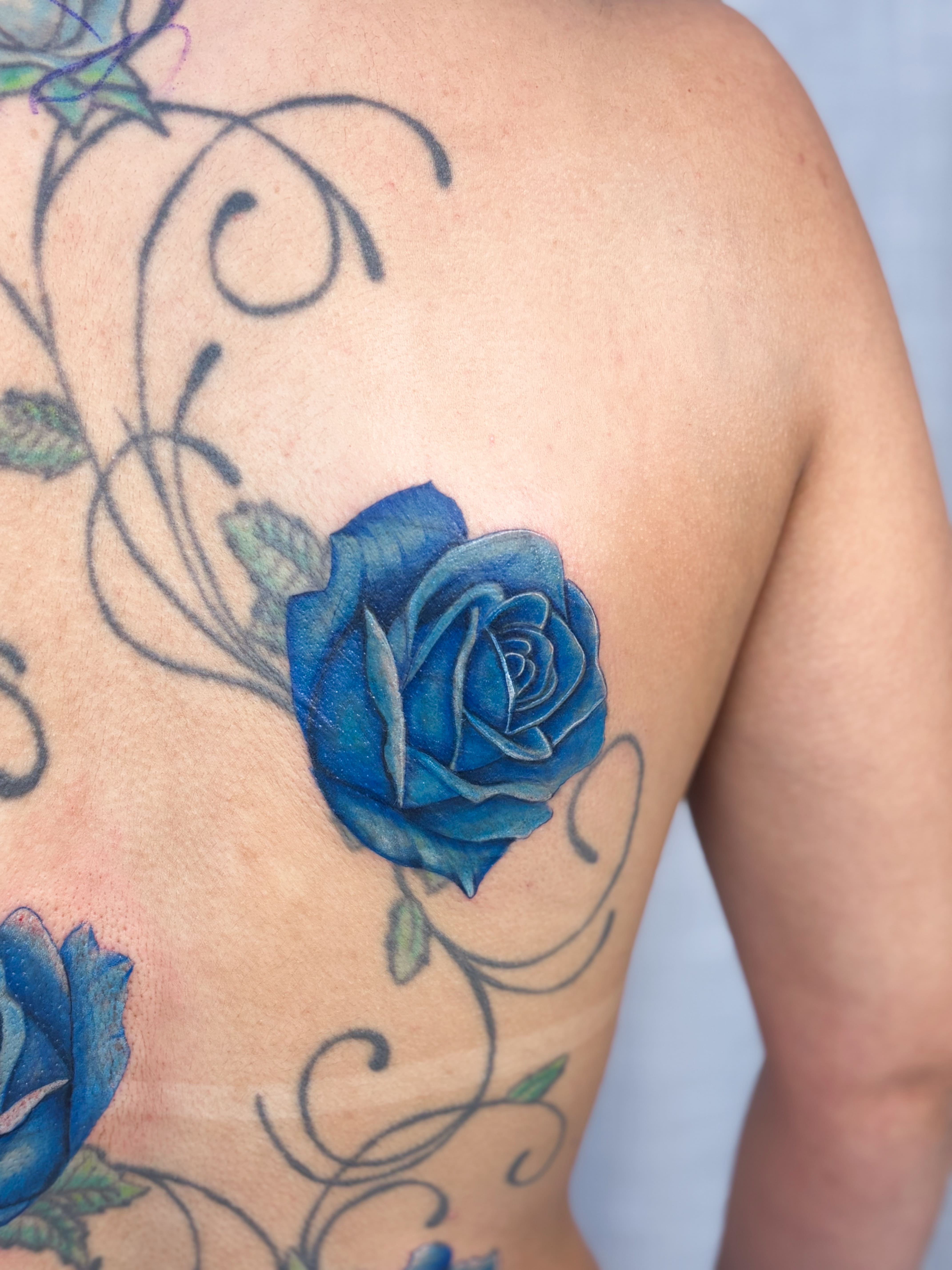 Tatuagem colorida realista de rosa azul